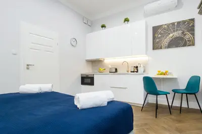 a room with a bed and two chairs and a kitchen at Old Town Residence at Topolowa in Kraków