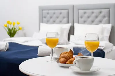 a table with two glasses of orange juice and croissants at Old Town Residence at Topolowa in Kraków