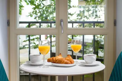 a table with two glasses of orange juice and croissants at Old Town Residence at Topolowa in Kraków
