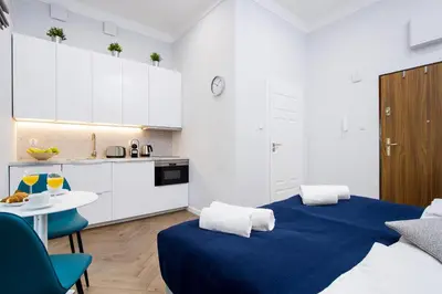 a room with two beds and a table and a kitchen at Old Town Residence at Topolowa in Kraków