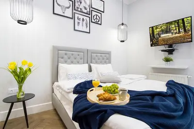 a room with a bed with a tray of food on it at Old Town Residence at Topolowa in Kraków