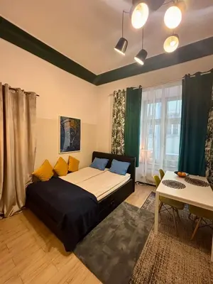 a bedroom with a large bed and a table at VINTAGE SENACKA APARTAMENTS in Kraków