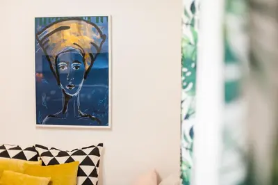 a painting of a woman on a wall next to a couch at VINTAGE SENACKA APARTAMENTS in Kraków