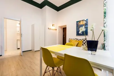 a dining room with a table and green chairs at VINTAGE SENACKA APARTAMENTS in Kraków