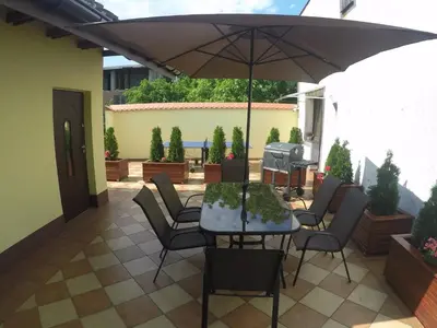 a patio with a table and chairs and an umbrella at Mączne Skały in Biały Kościół