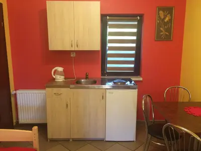 a kitchen with a sink and a red wall at Mączne Skały in Biały Kościół