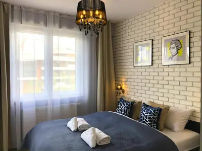 a bedroom with a blue bed with towels on it at Glamour Apartment with big, private terrace in Kraków