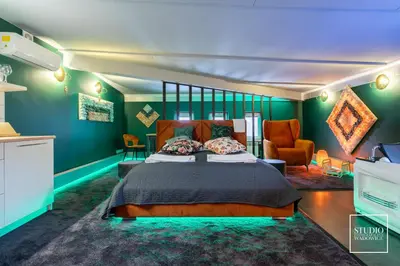 a bedroom with a bed and a green wall at Exclusive Apartment Centrum in Wadowice