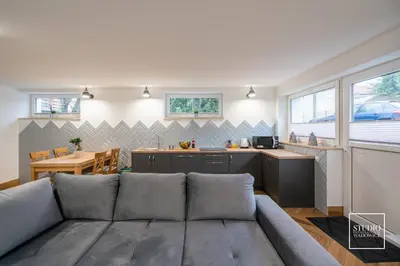 a living room with a couch and a kitchen at Exclusive Apartment Centrum in Wadowice