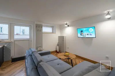 a living room with a couch and a tv on a wall at Exclusive Apartment Centrum in Wadowice