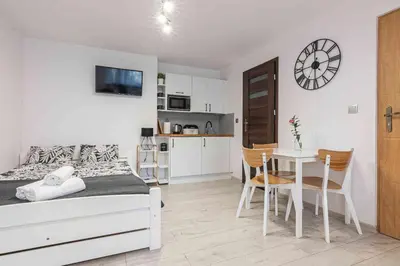 a bedroom with a bed and a table with chairs at Dworek na Zakręcie - noclegi Zator in Zator
