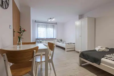 a room with a dining table and a bedroom at Dworek na Zakręcie - noclegi Zator in Zator