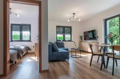 a bedroom and a living room with a bed and a table at Dworek na Zakręcie - noclegi Zator in Zator