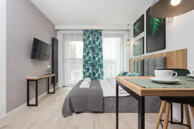 a bedroom with a bed and a table in it at City of the Kings - City Point Green - Rajska 3 in Kraków