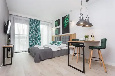 a bedroom with a bed and a desk and a table at City of the Kings - City Point Green - Rajska 3 in Kraków