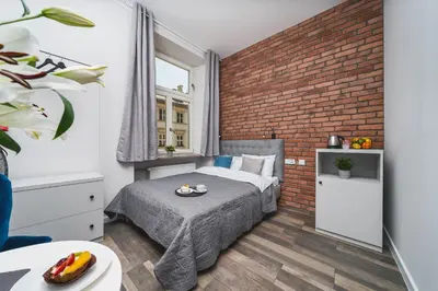 a bedroom with a bed and a brick wall at Liv Apartments Old Town in Kraków