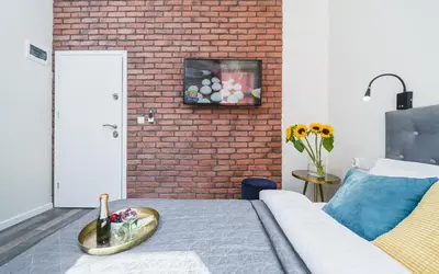 a room with a bed and a brick wall at Liv Apartments Old Town in Kraków