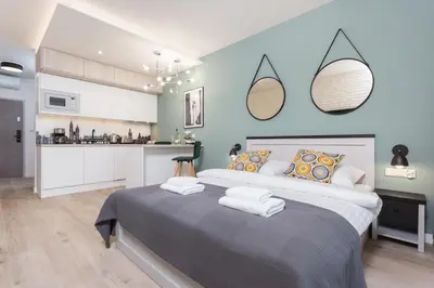 a bedroom with a large bed and a kitchen at City of the Kings - Asja Apartment - Rajska 3 in Kraków