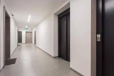 an empty hallway with black doors and white walls at City of the Kings - Asja Apartment - Rajska 3 in Kraków
