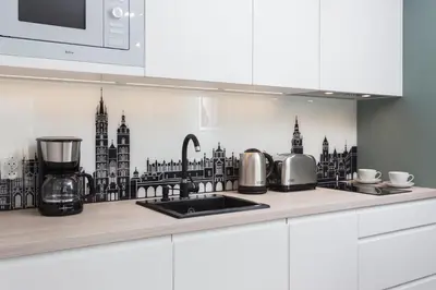 a kitchen counter with a black and white drawing on the wall at City of the Kings - Asja Apartment - Rajska 3 in Kraków