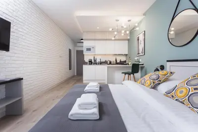 a bedroom with a large bed and a kitchen at City of the Kings - Asja Apartment - Rajska 3 in Kraków
