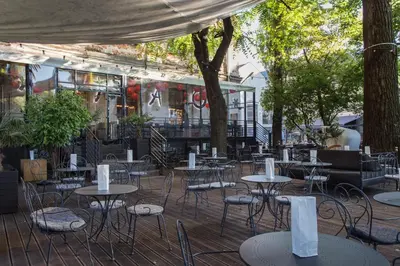 an outdoor patio with tables and chairs and trees at City of the Kings - Asja Apartment - Rajska 3 in Kraków