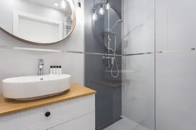 a white bathroom with a sink and a mirror at City of the Kings - Asja Apartment - Rajska 3 in Kraków