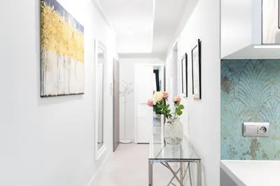 a hallway with a vase of flowers on a glass table at Rayska Loft Krakow by AS Apartments in Kraków