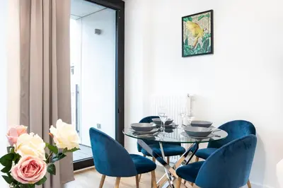 a dining room with a table and blue chairs at Rayska Loft Krakow by AS Apartments in Kraków