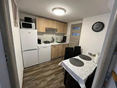 a small kitchen with a table and a white refrigerator at Premium Terrace Apartament in Kraków