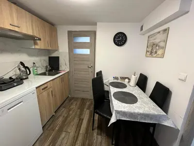 a kitchen with a table with chairs and a counter top at Premium Terrace Apartament in Kraków