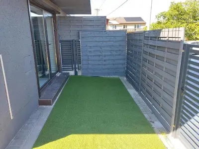 a patio with a green floor in front of a house at Premium Terrace Apartament in Kraków