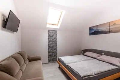 a bedroom with a bed and a couch and a window at Motel OLIV in Oświęcim