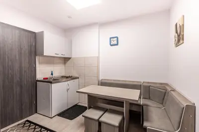 a room with a table and chairs and a kitchen at Motel OLIV in Oświęcim