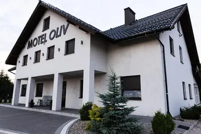 a white building with a tree in front of it at Motel OLIV in Oświęcim