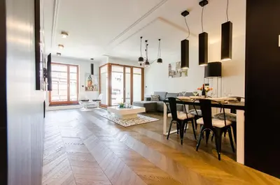 a dining room and living room with a table and chairs at Central Kazimierz Apartment with balcony in Kraków
