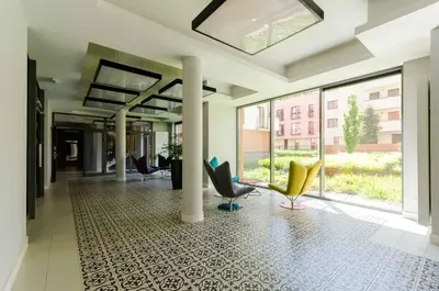 a lobby with chairs and windows in a building at Central Kazimierz Apartment with balcony in Kraków