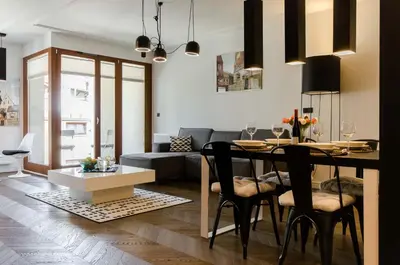 a dining room and living room with a table and chairs at Central Kazimierz Apartment with balcony in Kraków