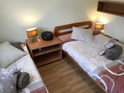 a bedroom with two beds and a night stand with two lamps at APARTAMENTY-STUDIO noclegi wczasy wakacje ferie - pobyty rodzinne in Rabka