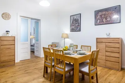 a dining room with a wooden table and chairs at Apartament Na Groblach in Kraków
