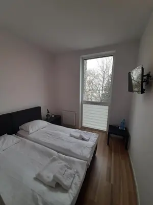 a bedroom with two beds and a window at Apartamenty Szlachecki Dwór in Pobiednik Wielki