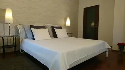 a bedroom with a bed with white sheets and pillows at Quiet and spacious apartment with garage option in Kraków