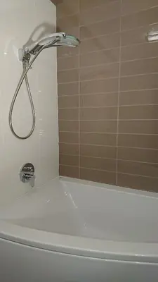 a shower with a faucet on top of a bath tub at Quiet and spacious apartment with garage option in Kraków
