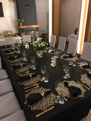 a long black table with glasses and napkins on it at Ośrodek Szkoleniowo Wypoczynkowy ROŻNÓW in Rożnów