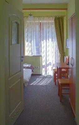 a room with a bedroom with a bed and a table at Ośrodek Szkoleniowo Wypoczynkowy ROŻNÓW in Rożnów
