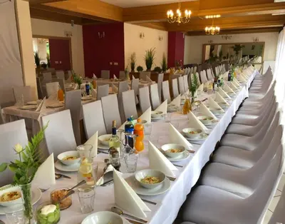 a long table with white tables and chairs at Ośrodek Szkoleniowo Wypoczynkowy ROŻNÓW in Rożnów