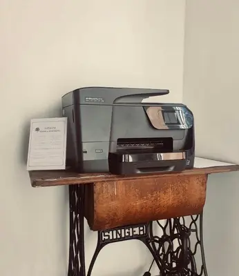 a computer printer sitting on a wooden table at Topolove Rooms & Apartments in Kraków