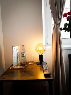 a table with a lamp a remote control and a glass at Topolove Rooms & Apartments in Kraków