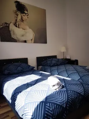 a bed with a blue and white comforter in a bedroom at Topolove Rooms & Apartments in Kraków