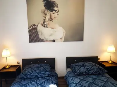 two beds in a room with a picture on the wall at Topolove Rooms & Apartments in Kraków